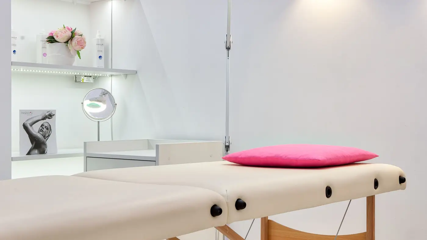 Heller Behandlungsraum mit Liege und Lampe